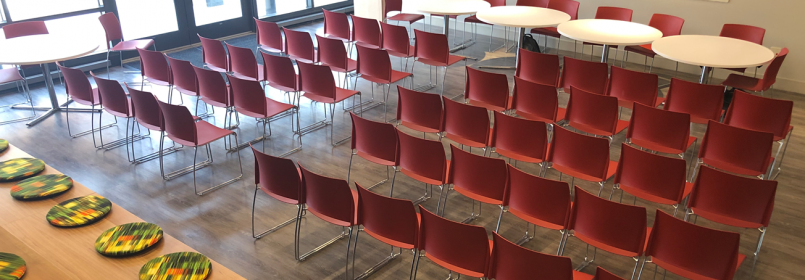Picture of a room full of red chairs and round tables