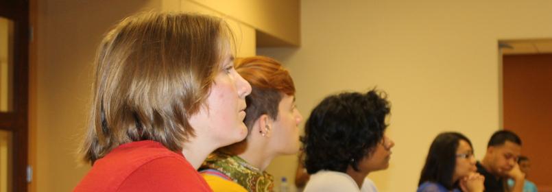 Side view of students listening to a speaker